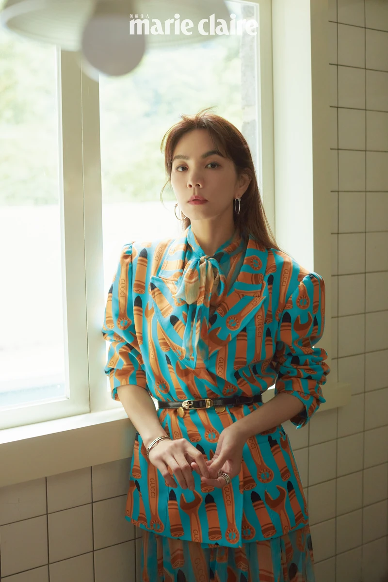 印花長袖墊肩夾克、印花蝴蝶結襯衫、印花中長裙、高腰帶，all by Gucci。B.zero1 白金鑽石耳環、B.zero1 系列白金三環鑽石戒指，白K金三環戒指，外圈飾以密鑲鑽石、B.zero1系列玫瑰金三環鑽石戒指、B.zero1 系列白金手環，all by BVLGARI。