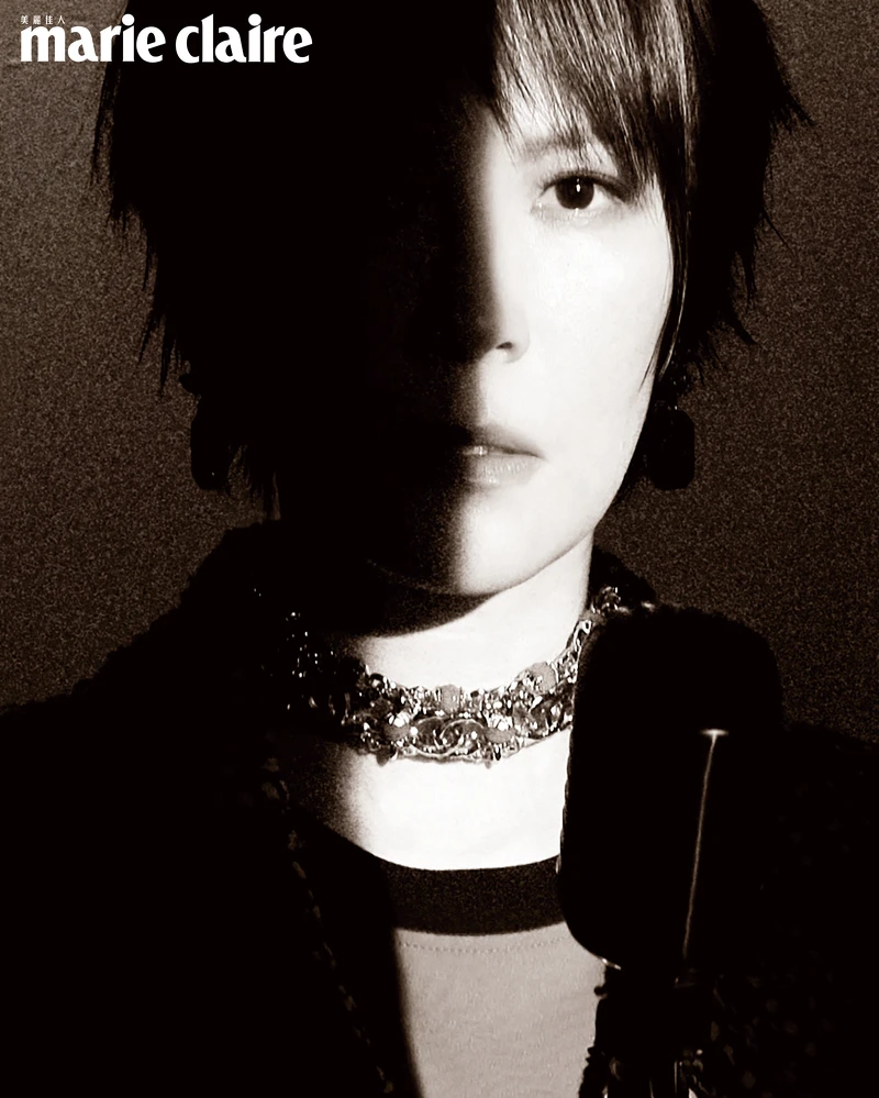 斜紋軟呢長版大衣、Logo 長袖上衣、吊墜耳環、金色 Logo 頸鍊，all by CHANEL。