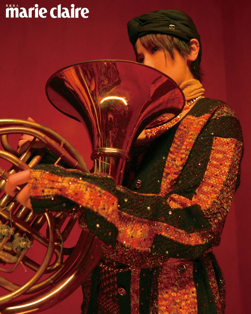 金色高領針織上衣、橘色拼接針織背心、橘色拼接針織外套、黑色帽飾、橘色串珠項鍊、橘色串珠腰鍊，all by CHANEL。