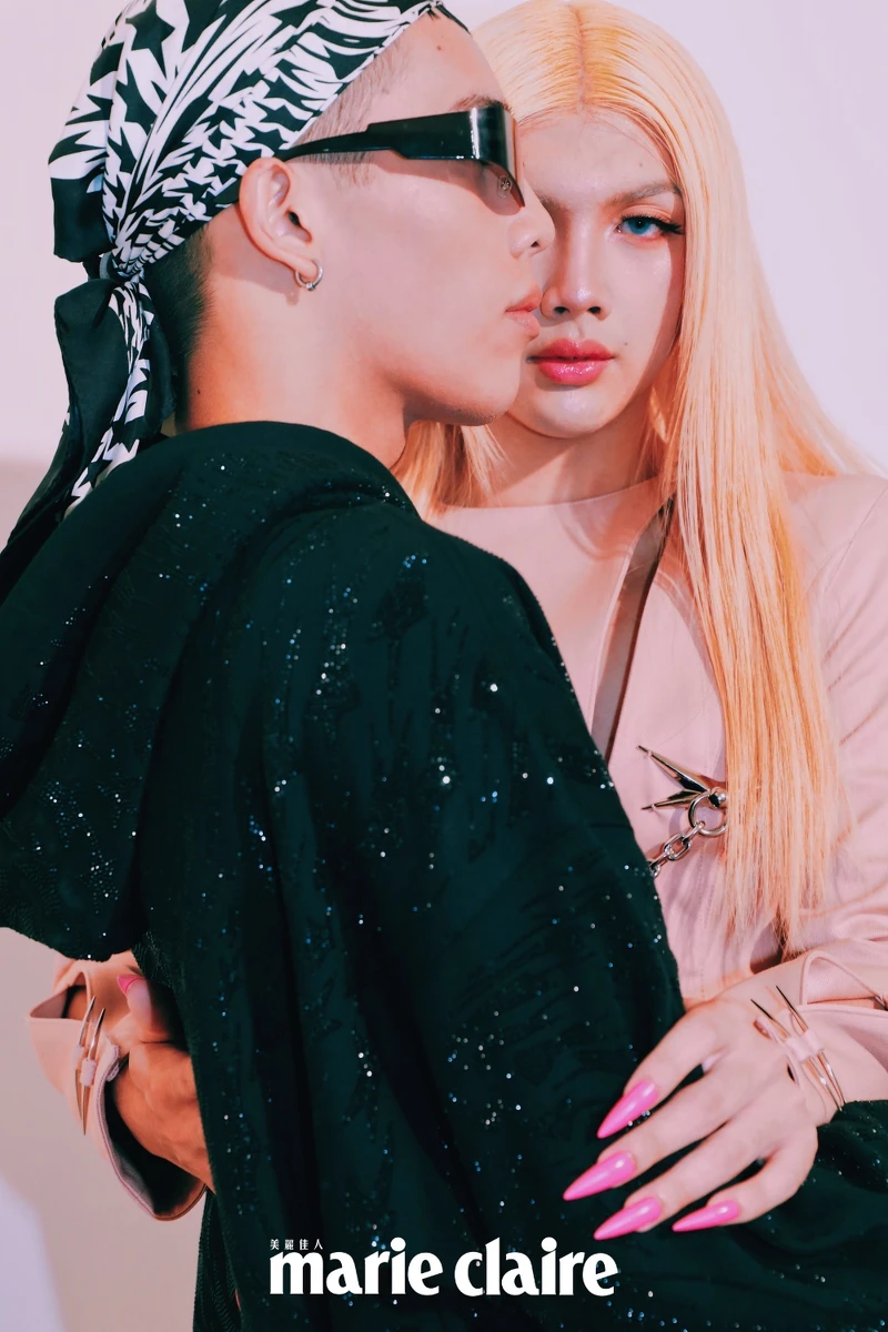 （左）Jason Versace、（右）Rochelle Versace（Jason Jason Versace ）剪裁牛仔褲、滿鑽連帽上衣、漸變印花絲巾、漸變印花頭巾，all by Mugler H&M。(Rochelle Versace )復古剪裁粉色套裝、螢光粉剪裁絲褲、星星耳環、變形星星別針鏈飾，all by Mugler H&M。 