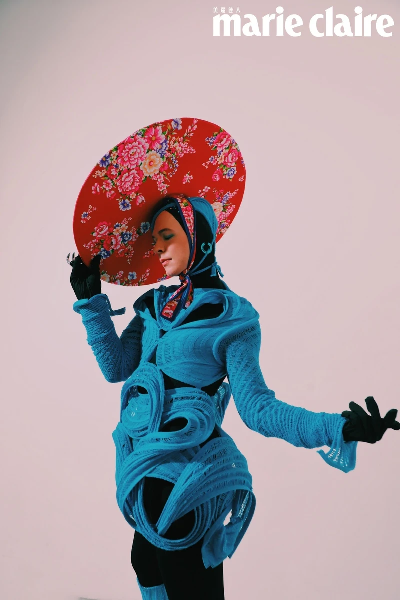 藍色剪裁針織連衣裙、黑色連體衣、藍色剪裁針織帽飾、藍色針織靴，all by LIN LU；(Kelly Vase )Lucent 藍色大圈耳環、Numina 個性戒指、Chroma 個性戒指 ，all by Swarovski。