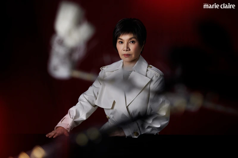 墨綠色針織鏤空洋裝，Brunello Cucinelli。米色長風衣，BOSS。