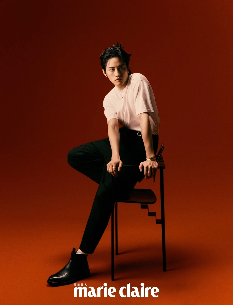 白色針織短袖上衣、打褶寬褲，all by LOEWE；Jonboy 切爾西牛皮短靴，ALLSAINTS；Possession系列玫瑰金宮廷式雕刻飾紋鑽石手鐲、玫瑰金宮廷式雕刻飾紋鑽石戒指、玫瑰金宮廷式雕刻飾紋彩色寶石戒指、玫瑰金宮廷式雕刻飾紋鑽石項鍊、玫瑰金祖母綠鑽石耳環，all by PIAGET。