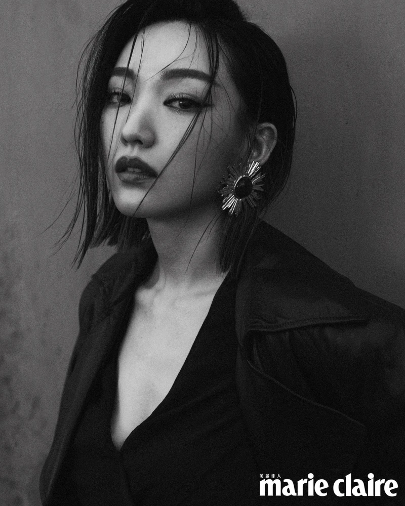 深咖啡色皮革大衣、黑色綁帶罩衫、咖啡色皮革長裙、黑色尖頭高跟鞋、造型耳環，all by Saint Laurent。