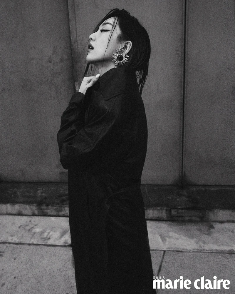 深咖啡色皮革大衣、黑色綁帶罩衫、咖啡色皮革長裙、黑色尖頭高跟鞋、造型耳環，all by Saint Laurent。