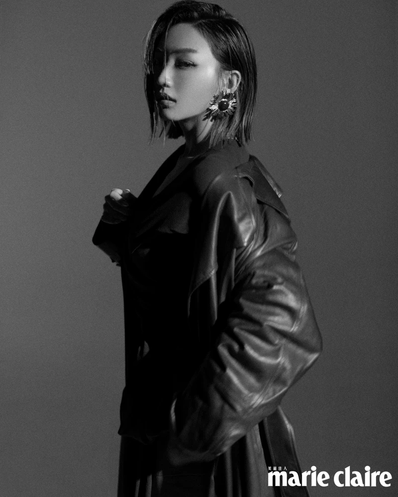 深咖啡色皮革大衣、黑色綁帶罩衫、咖啡色皮革長裙、黑色尖頭高跟鞋、造型耳環，all by Saint Laurent。