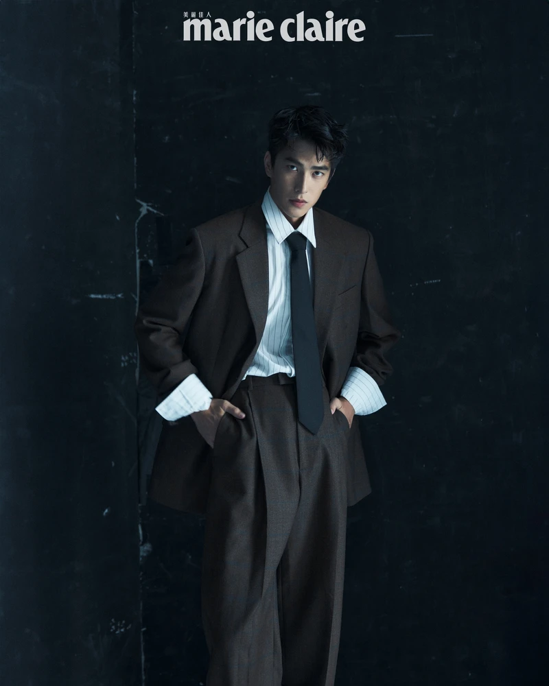 咖啡色西裝外套、咖啡色西裝長褲、白色條紋襯衫、黑色領帶，all by Bottega Veneta。