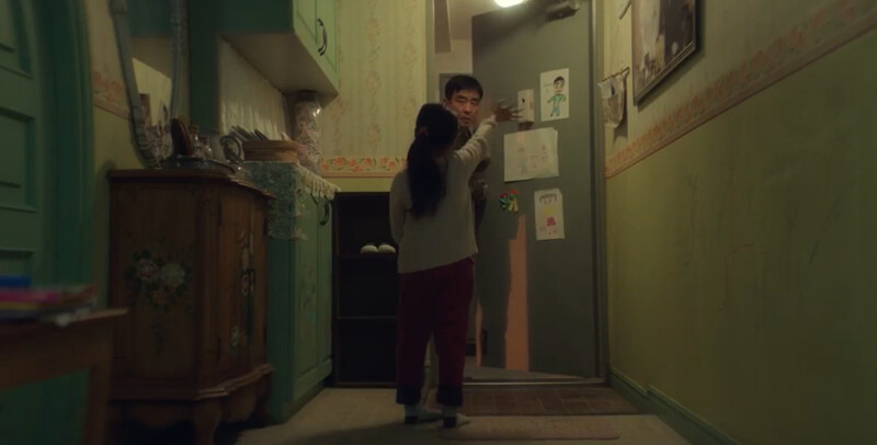 喜秀(背對者)像媽媽一樣，搖搖手點亮感應燈，再目送張洙源出門上班，張洙源說再見久久無法闔上門