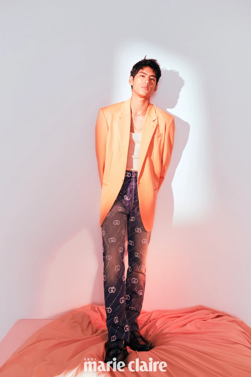 象牙色圓領針織衫、橘色西裝外套、水鑽刺繡牛仔長褲，all by Gucci；Quatre系列鍊墜項鍊、Quatre系列Y字鍊；皮革鞋，Pedro。