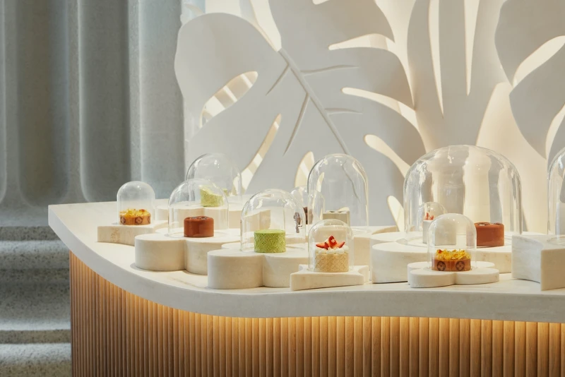 大型的弧形展示桌，陳列著精選的甜點。