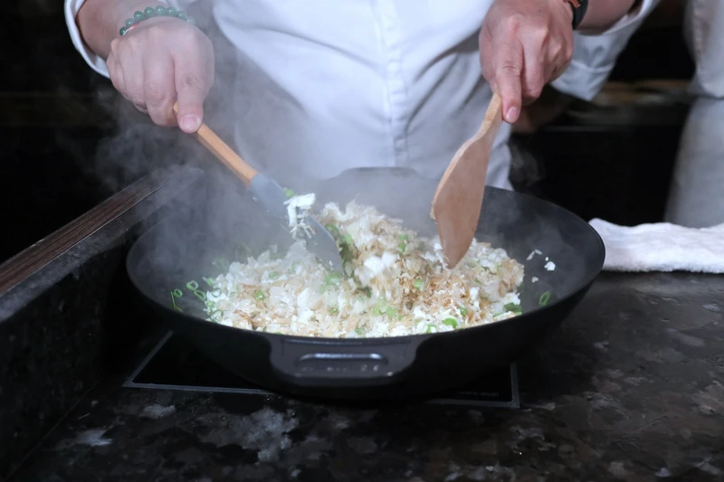 在包廂內的爐台上拌炒，確保每份炒飯的溫度與風味。