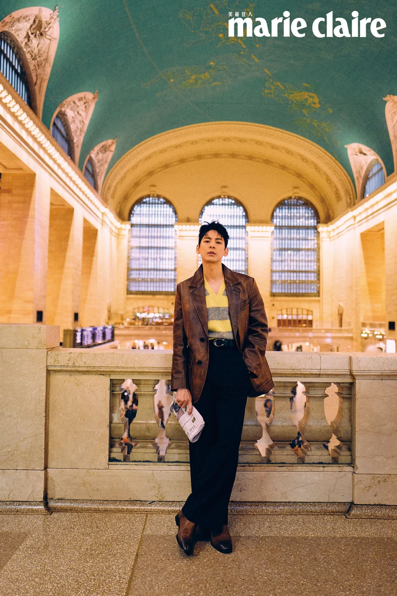 咖啡色皮質西裝外套、黃色條紋背心、皮帶、黑色西裝寬褲、咖啡色皮質長靴，all by Coach。