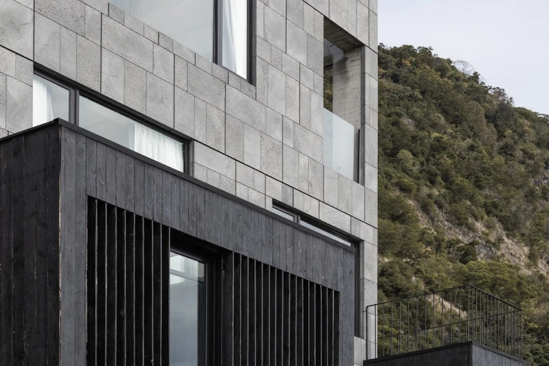 灰色的建築線條現代簡約，在壯闊的海岸山脈下顯得特別搶眼。