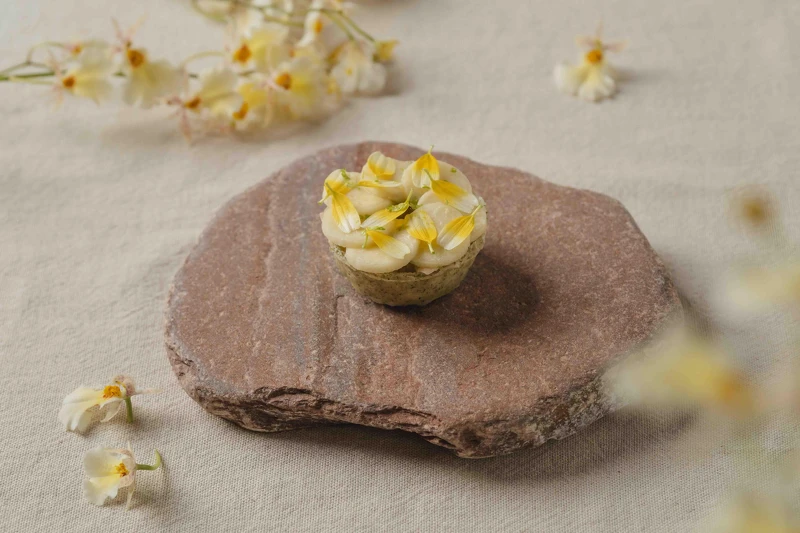 「蛤蠣、筊白筍、番茄」-經典的新鮮蛤蜊,加入了茭白筍和發酵番茄高湯凍,層層鋪疊,融合出細膩馥郁的風味,再點綴以黃色的茼蒿花,增添視覺和味覺的雙重享受。檸檬皮碎與巴西里油的細緻點綴,為這道菜帶來一絲清新的口感。薄脆的塔殼與帶有鮮味的澄清番茄凍完美結合,為您呈現夏日的清新美味。 「蛤蠣、筊白筍、番茄」-經典的新鮮蛤蜊,加入了茭白筍和發酵番茄高湯凍,層層鋪疊,融合出細膩馥郁的風味,再點綴以黃色的茼蒿花,增添視覺和味覺的雙重享受。檸檬皮碎與巴西里油的細緻點綴,為這道菜帶來一絲清新的口感。薄脆的塔殼與帶有鮮味的澄清番茄凍完美結合,為您呈現夏日的清新美味。