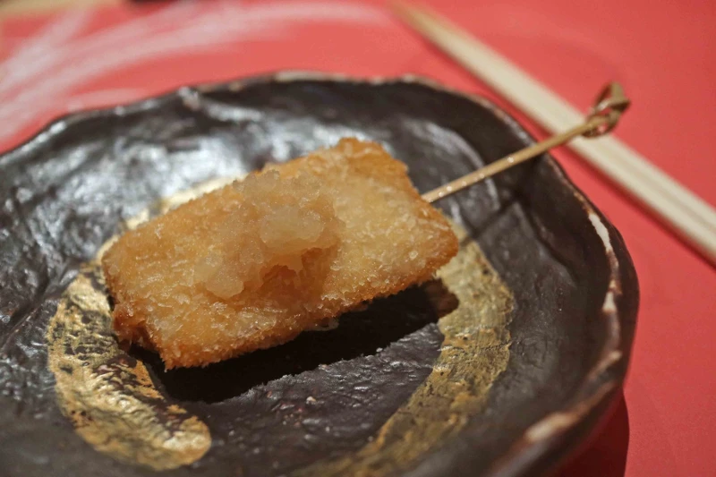 白油旗魚切片經過麵粉、蛋液和細麵包粉的層層包裹後酥炸。
