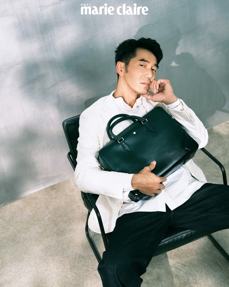 飄帶白襯衫、白色棉麻西裝外套，both by Boss；深藍牛仔寬褲，Loewe；萬寶龍大師傑作系列公文包，Montblanc。