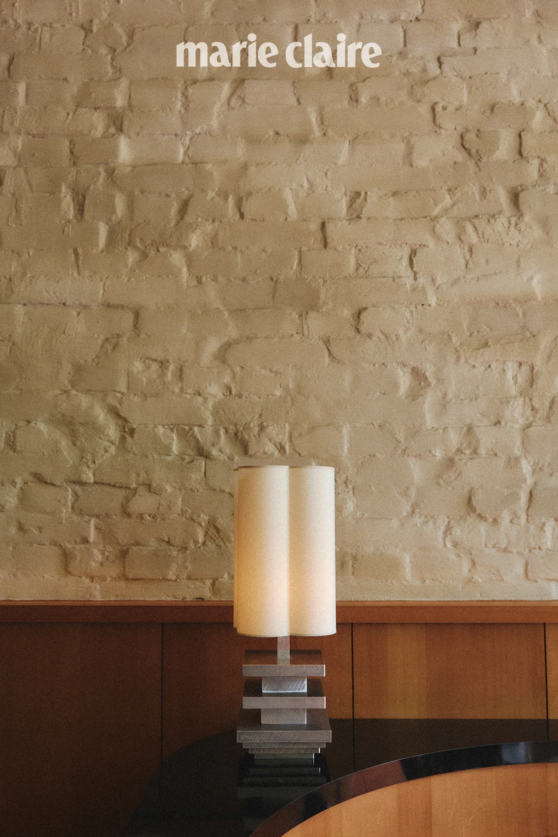 牆面使用了中世紀常見的實木壁板，混搭歐洲造屋古法所使用的石灰漆磚牆，而空間裡頭的每一盞燈不但造型典雅，各自又擁有獨特的個性。