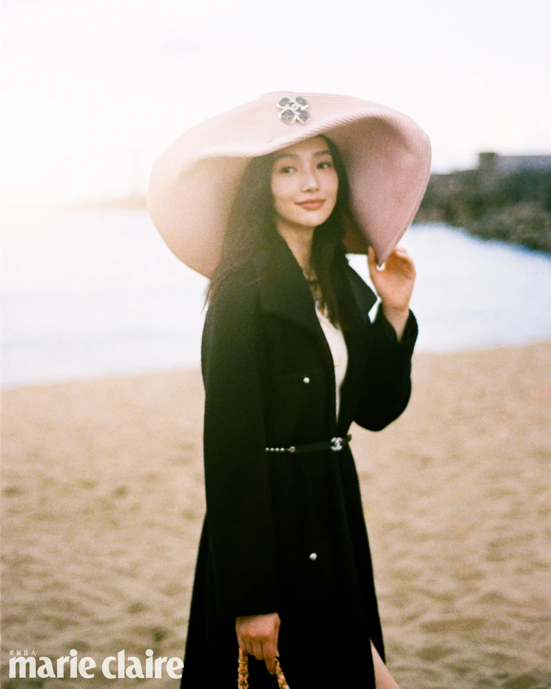 (Cecilia Choi)黑色斜紋軟呢長版綁帶大衣、白色針織洋裝、粉色寬沿草帽、皮穿鍊腰鍊、橘色皮革菱紋口蓋包,all by Chanel。 (Cecilia Choi)黑色斜紋軟呢長版綁帶大衣、白色針織洋裝、粉色寬沿草帽、皮穿鍊腰鍊、橘色皮革菱紋口蓋包,all by Chanel。