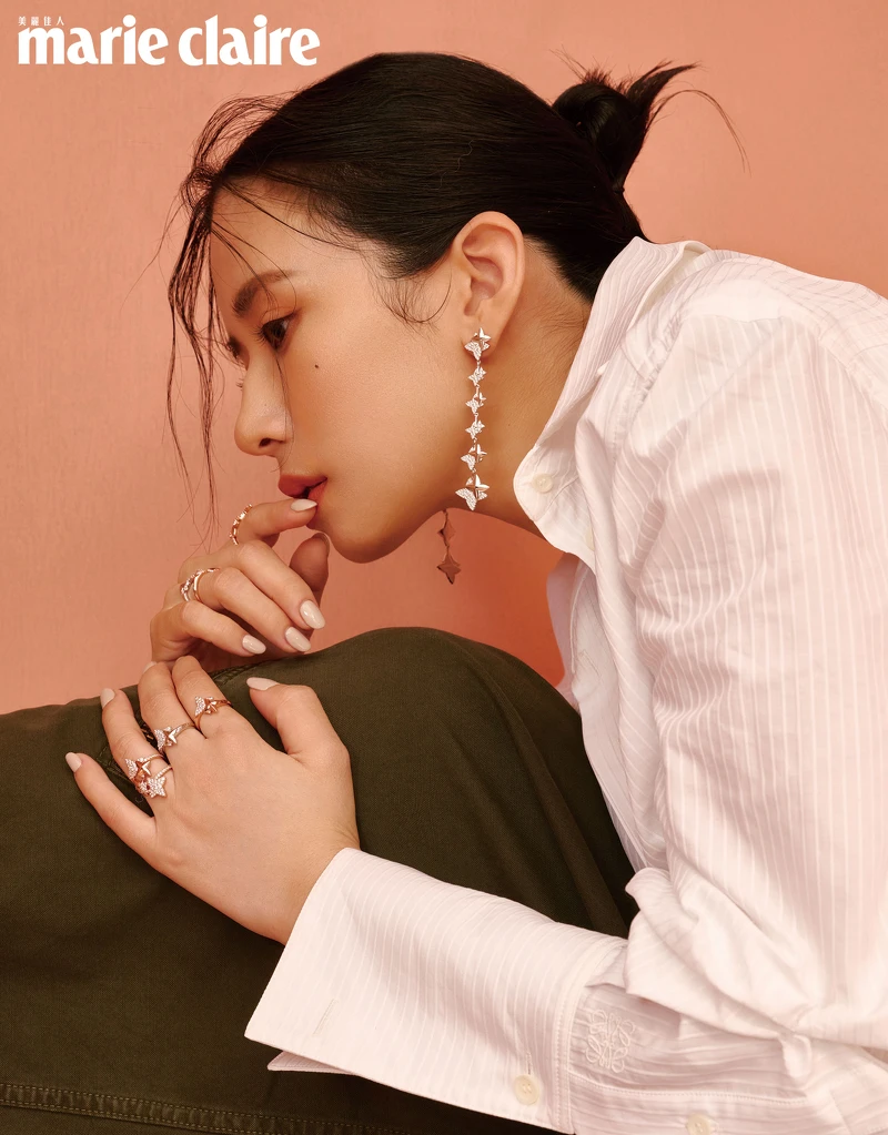 白色腰帶襯衫、軍綠色工裝褲，both by Loewe；軍綠色高跟鞋，Ferragamo；六芒星銀色垂墜耳環、六芒星可調節項鍊、雙流星可調節項鍊、六芒星戒指，all by APM Monaco。