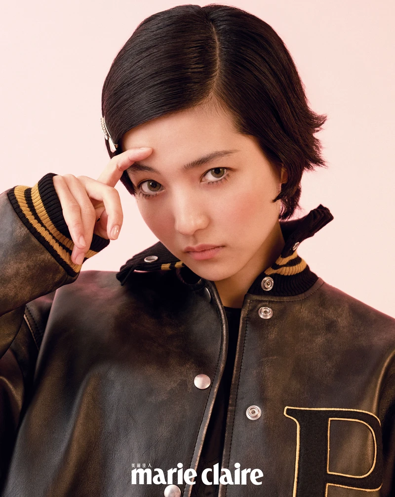 P 補丁綴飾皮革球隊夾克、絲質洋裝、水晶綴飾金屬髮夾,all by Prada。 P 補丁綴飾皮革球隊夾克、絲質洋裝、水晶綴飾金屬髮夾,all by Prada。