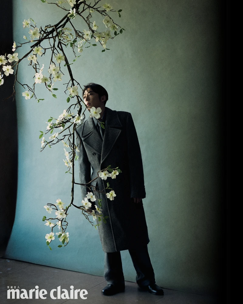 灰色大衣、灰色毛呢襯衫、灰色毛呢領帶、灰色西裝長褲、黑色皮靴，all by Bottega Veneta。