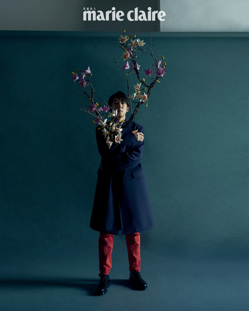 深藍色大衣、粉色襯衫、草綠色絲質領帶、紅色針織長褲，all by Prada。