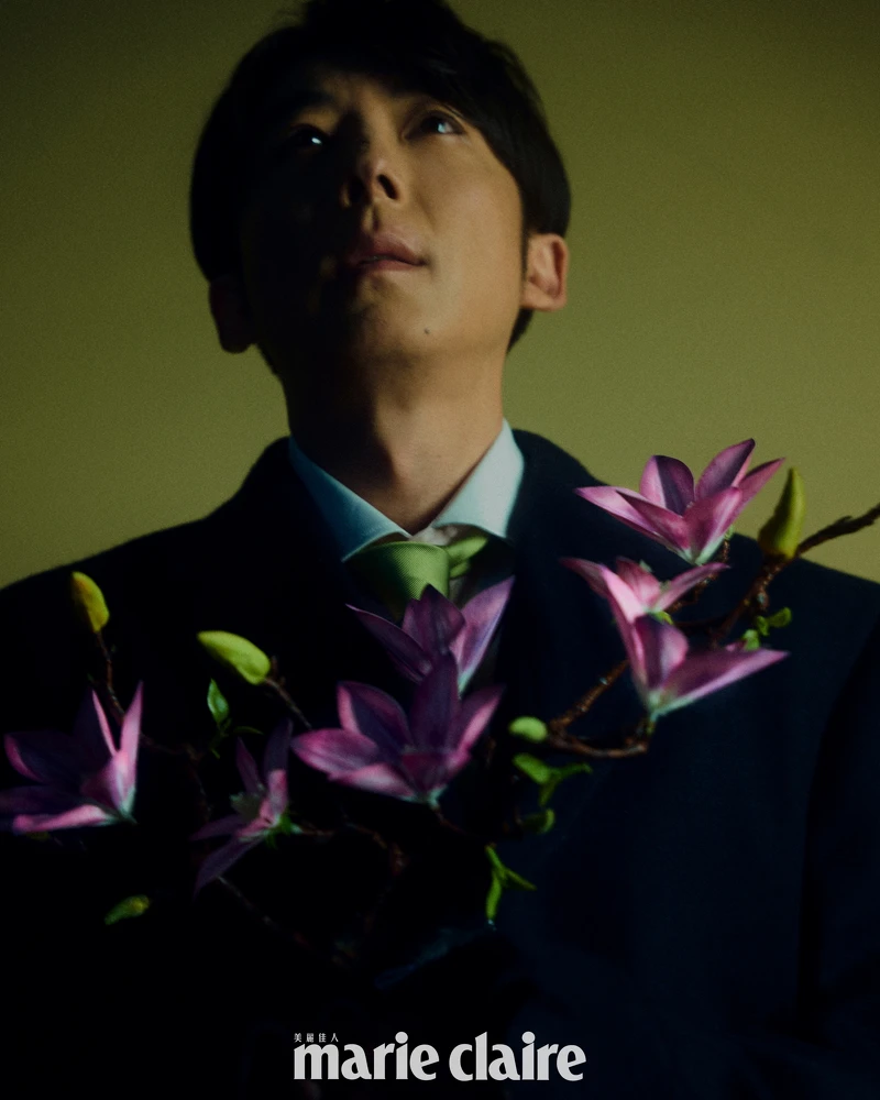 深藍色大衣、粉色襯衫、草綠色絲質領帶，all by Prada。