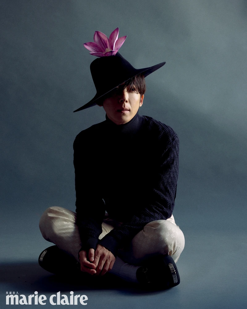 黑色高領針織衫，Prada；杏色印花西裝褲，Balmain；黑色尖頭皮鞋，Gucci。