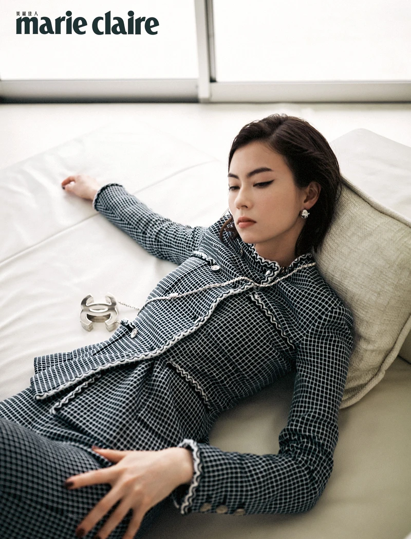 黑白斜紋軟呢外套、黑色斜紋軟呢長褲、銀色金屬耳環、銀色雙C logo掛飾，all by Chanel。