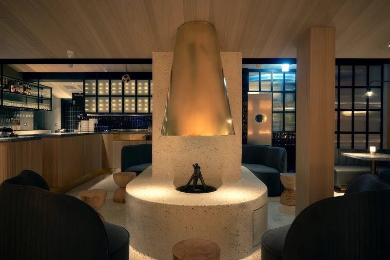 台北店空間以奶油色磨石子材質打造的無接縫地板,並延伸至火爐。 台北店空間以奶油色磨石子材質打造的無接縫地板,並延伸至火爐。