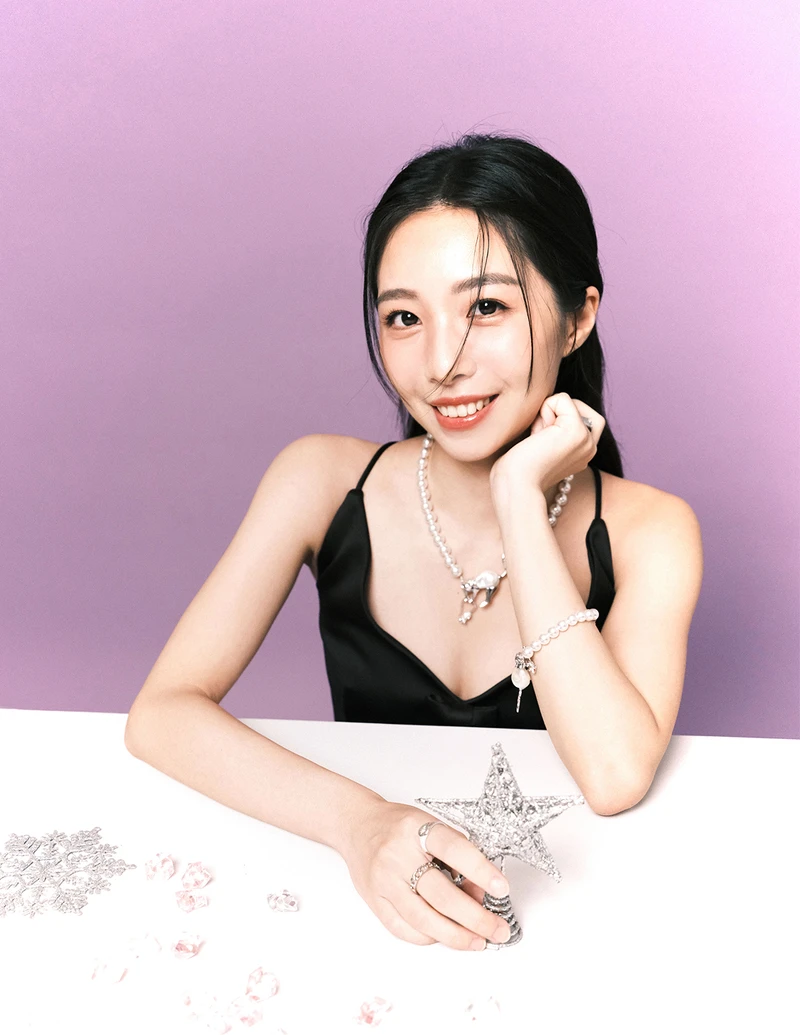 黑色蝴蝶結短洋裝、珍珠項鍊、珍珠手鍊，all by Marc Jacobs。