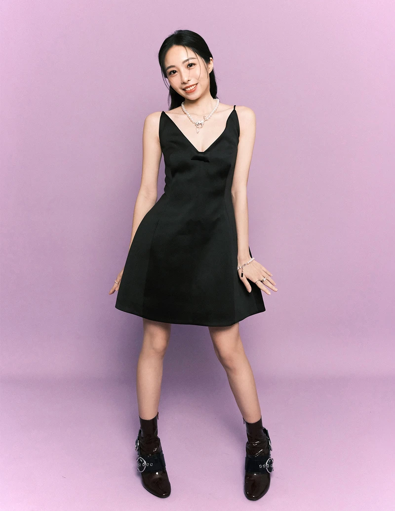 黑色蝴蝶結短洋裝、珍珠項鍊、珍珠手鍊，all by Marc Jacobs。