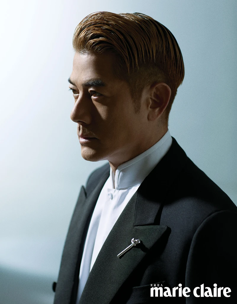 黑色羊毛和絲綢雙排扣西裝、白色棉質立領襯衫,both by Loro Piana;銀色扭結胸針、黑色皮靴,both by Bottega Veneta。 黑色羊毛和絲綢雙排扣西裝、白色棉質立領襯衫,both by Loro Piana;銀色扭結胸針、黑色皮靴,both by Bottega Veneta。