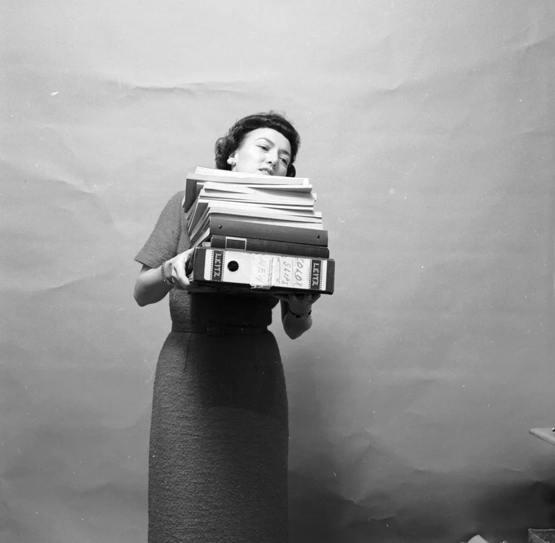 circa 1955: A secretary struggling to see over her load of files. (Photo by Carsten/Three Lions/Getty Images)|© Getty Images circa 1955: A secretary struggling to see over her load of files. (Photo by Carsten/Three Lions/Getty Images)|© Getty Images