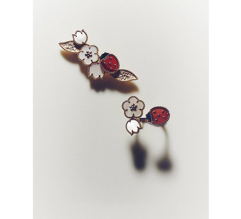 Lucky Spring 系列18K 玫瑰金鑲嵌珍珠母貝、紅玉髓及縞瑪瑙胸針與指間戒,both by Van Cleef & Arpels。 Lucky Spring 系列18K 玫瑰金鑲嵌珍珠母貝、紅玉髓及縞瑪瑙胸針與指間戒,both by Van Cleef & Arpels。