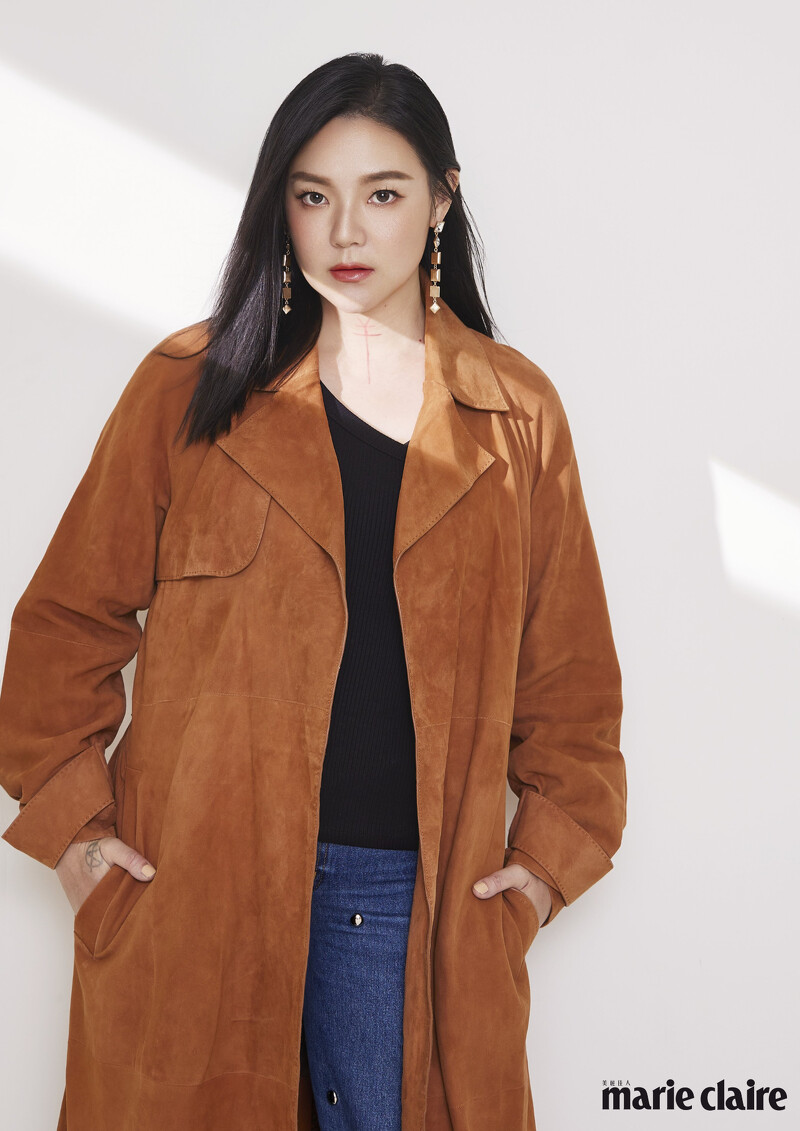 褐色麂皮大衣，Boss;黑色上衣、鉚釘丹寧長褲、耳環all byAllsaints。