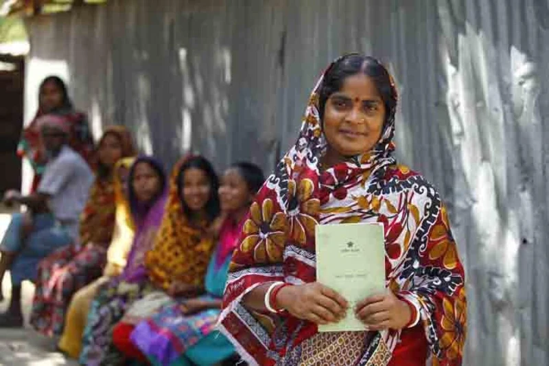 婦女的手裡拿著鄉村銀行的流程手冊。她們為了要能貸款，必須要一步一步遵守所有銀行所開出以婦女為考量的約定。