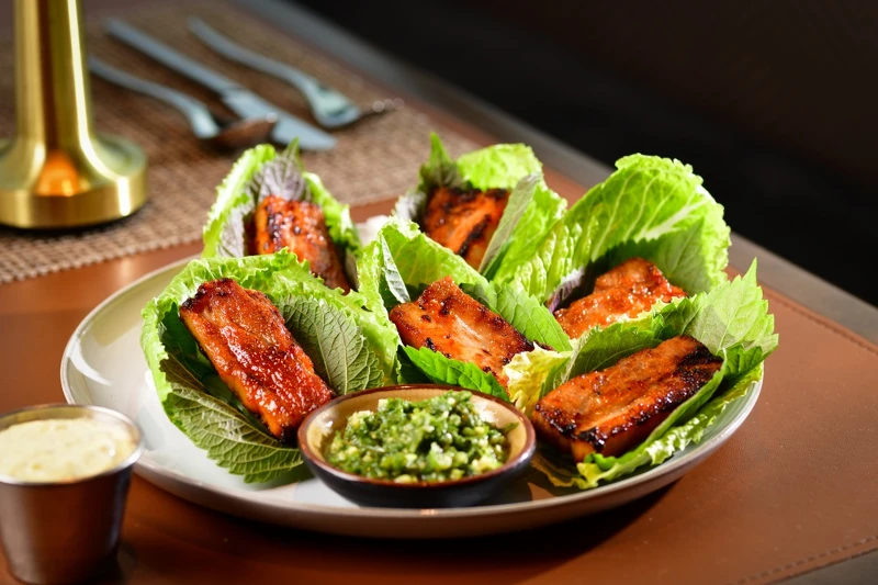 烤豬腹肉搭配生菜與芝麻葉。 烤豬腹肉搭配生菜與芝麻葉。