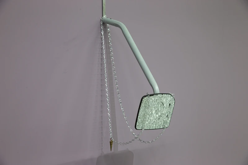 黃麗音，《注意後方來車》，2025，破碎的後視鏡、銅、鋁、鍊條，115 × 22 × 31公分。圖像由北美館提供。