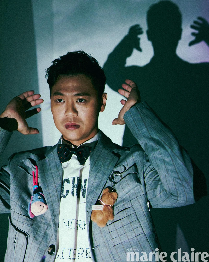 煙灰色工裝直條紋西裝外套、白色 Logo 標語襯衫、煙灰色工裝直條紋西裝褲,All by Moschino;彩色星星領結、黑色皮鞋,Both by Paul Smith。 煙灰色工裝直條紋西裝外套、白色 Logo 標語襯衫、煙灰色工裝直條紋西裝褲,All by Moschino;彩色星星領結、黑色皮鞋,Both by Paul Smith。