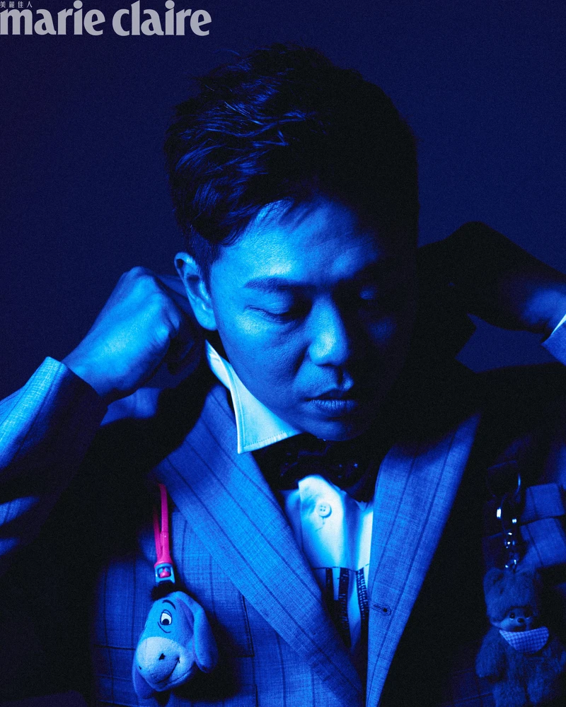 煙灰色工裝直條紋西裝外套、白色 Logo 標語襯衫、煙灰色工裝直條紋西裝褲,All by Moschino;彩色星星領結、黑色皮鞋,Both by Paul Smith。 煙灰色工裝直條紋西裝外套、白色 Logo 標語襯衫、煙灰色工裝直條紋西裝褲,All by Moschino;彩色星星領結、黑色皮鞋,Both by Paul Smith。