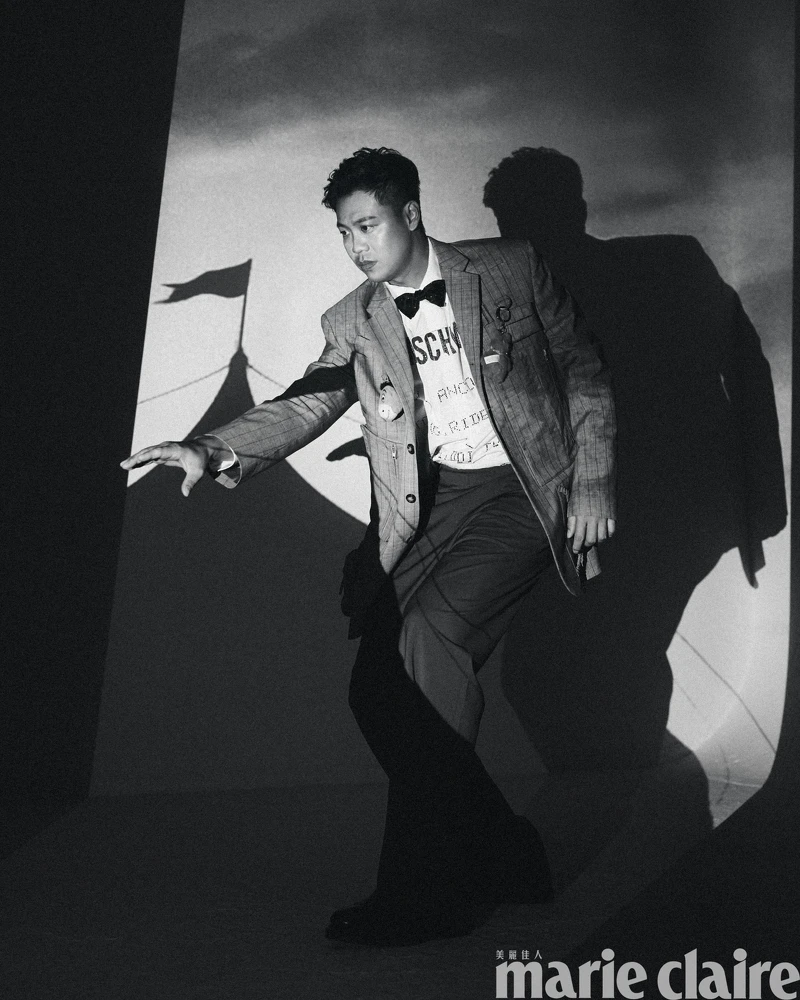 煙灰色工裝直條紋西裝外套、白色 Logo 標語襯衫、煙灰色工裝直條紋西裝褲,All by Moschino;彩色星星領結、黑色皮鞋,Both by Paul Smith。 煙灰色工裝直條紋西裝外套、白色 Logo 標語襯衫、煙灰色工裝直條紋西裝褲,All by Moschino;彩色星星領結、黑色皮鞋,Both by Paul Smith。