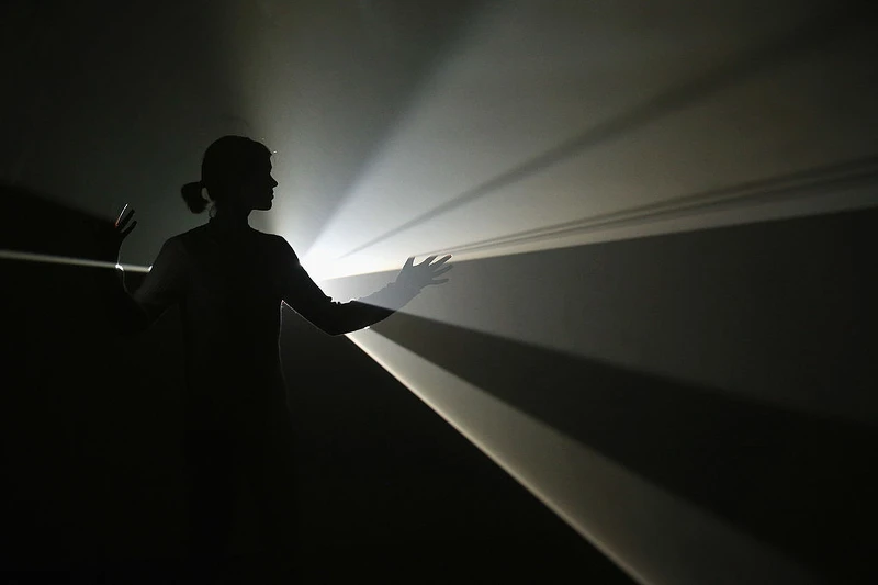 女子與安東尼・麥考（Anthony McCall）的藝術裝置《你與我，水平》（You and I, Horizontal）互動，該作品為海沃德畫廊（Hayward Gallery）展覽《光之展》（Light Show）的一部分。《光之展》展出25件由國際重要藝術家自1960年代至今創作的光影裝置與雕塑。（照片來源：Oli Scarff／Getty Images）