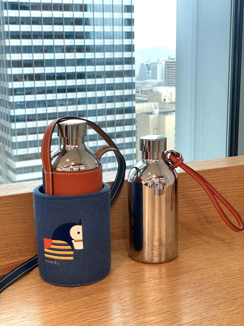 Hermès Flâneuse 隨身水瓶系列,流線鏡面外觀與撞色皮革手腕帶 Hermès Flâneuse 隨身水瓶系列,流線鏡面外觀與撞色皮革手腕帶