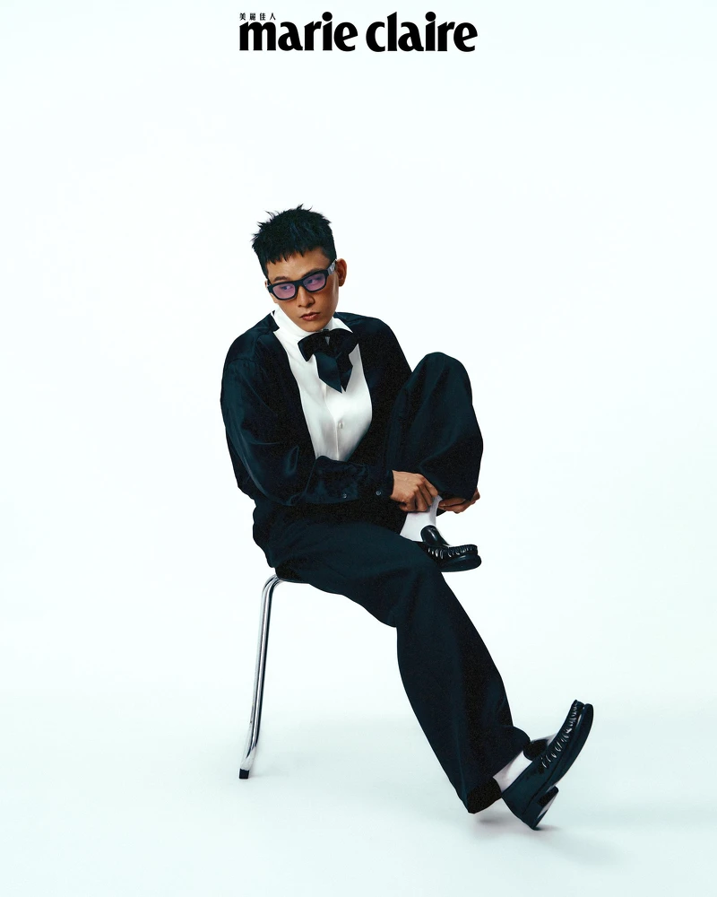 緞面襯衫、黑色西裝褲，both by Loewe；黑色皮鞋，Prada；Symbole 太陽眼鏡，Prada Eyewear。