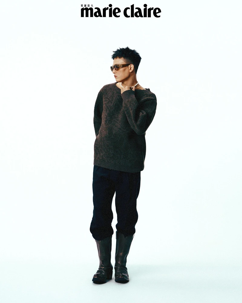 橘色短袖上衣、灰棕色毛衣，both by Prada；黑色西裝褲、琥珀色墨鏡 both by Loewe。琥珀色墨鏡，Loewe。