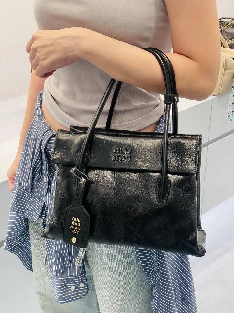 Miu Miu 新款黑色皮革肩背包,具三層收納空間與裂紋皮革 Miu Miu 新款黑色皮革肩背包,具三層收納空間與裂紋皮革